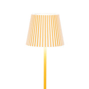 Yellow floor lamp with a striped shade on a white background